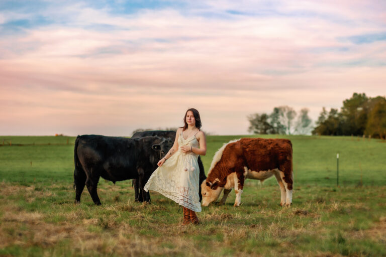 country graduation senior photo session - girl dancing between cows