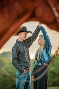 Cowboy and cowgirl dancing behind a Horse