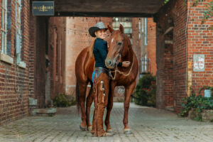 Cowgirl and her sorrel mare in City